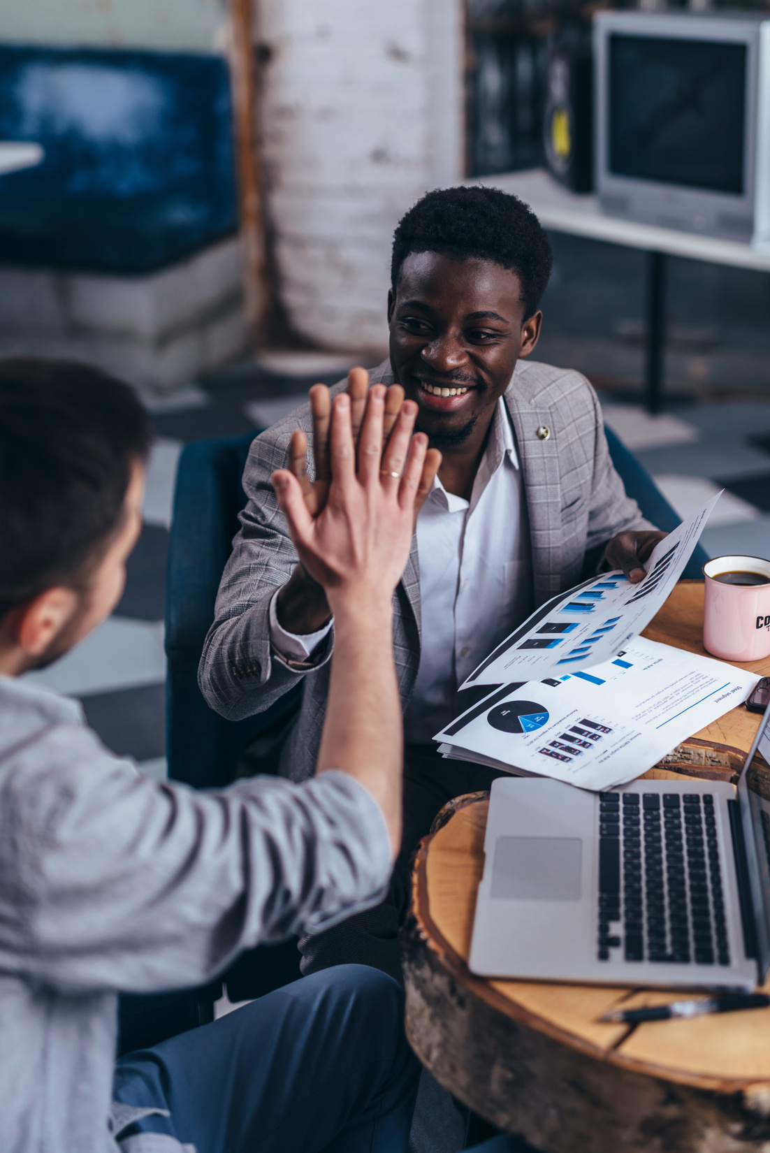 Business Partners Giving High Five at Table.